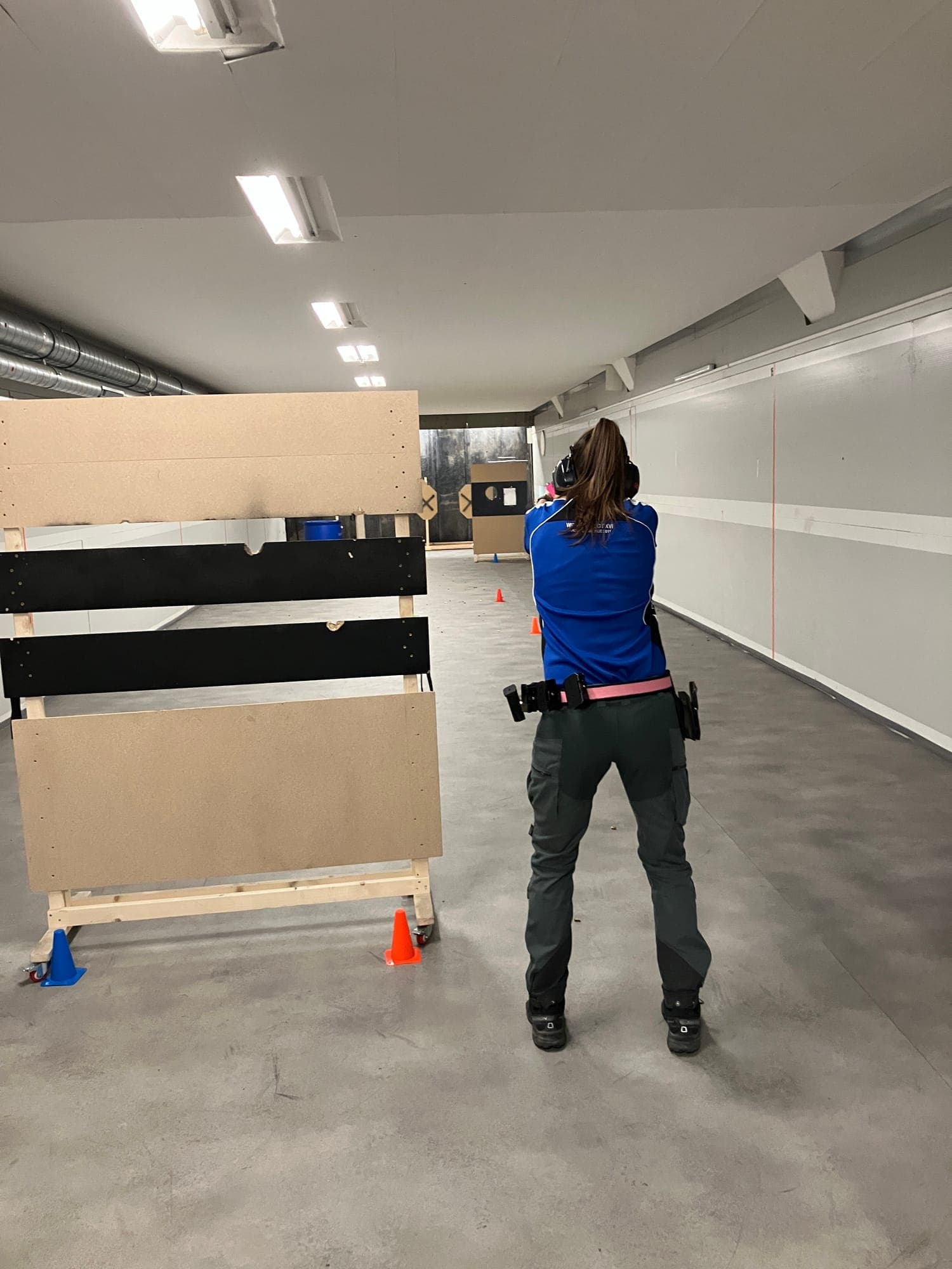Schützin mit Pistole an einer Barrikade auf der Indoor-Anlage