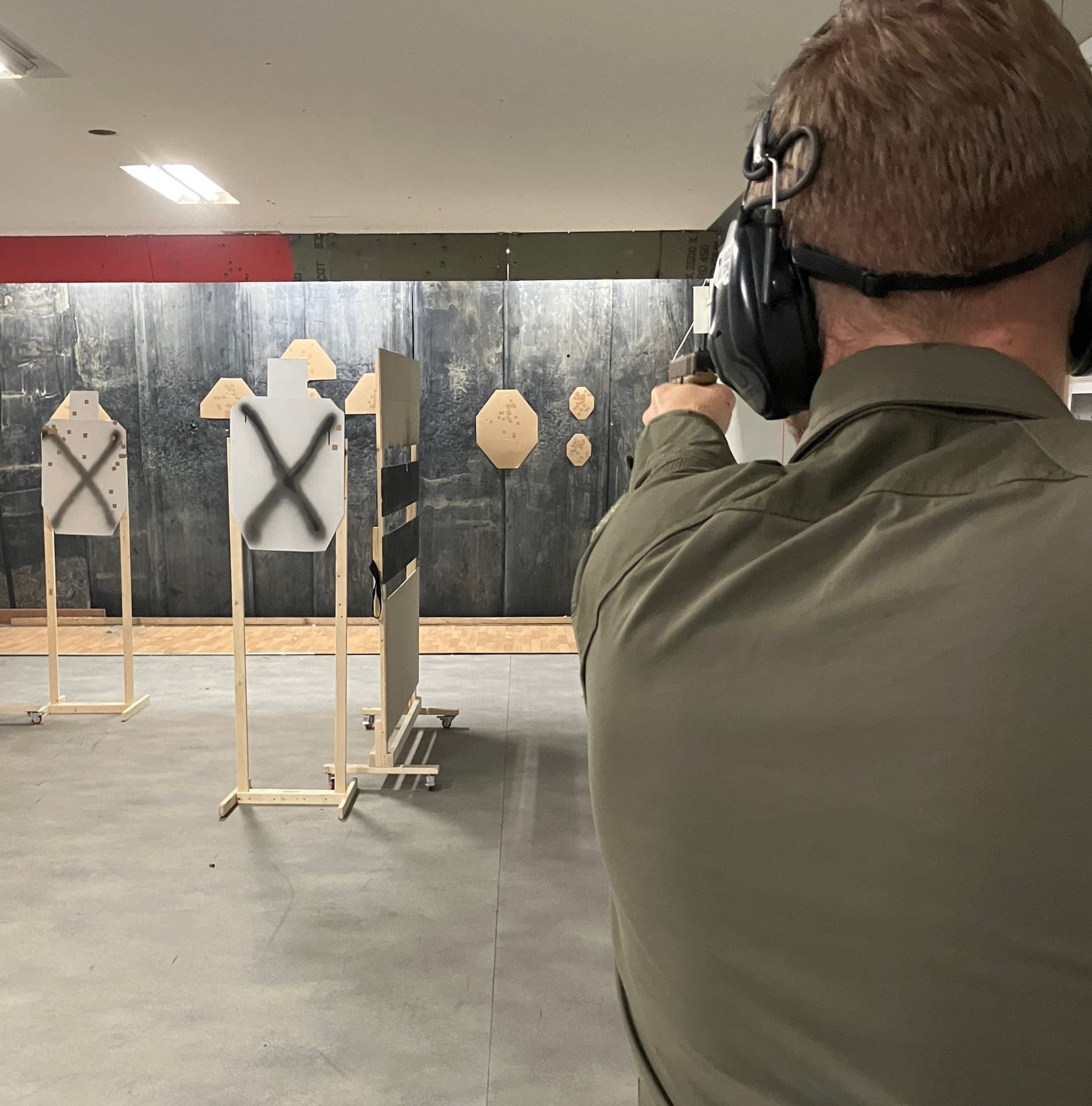 Schütze zielt im Parcours auf Ziele hinter Holzbarrikaden