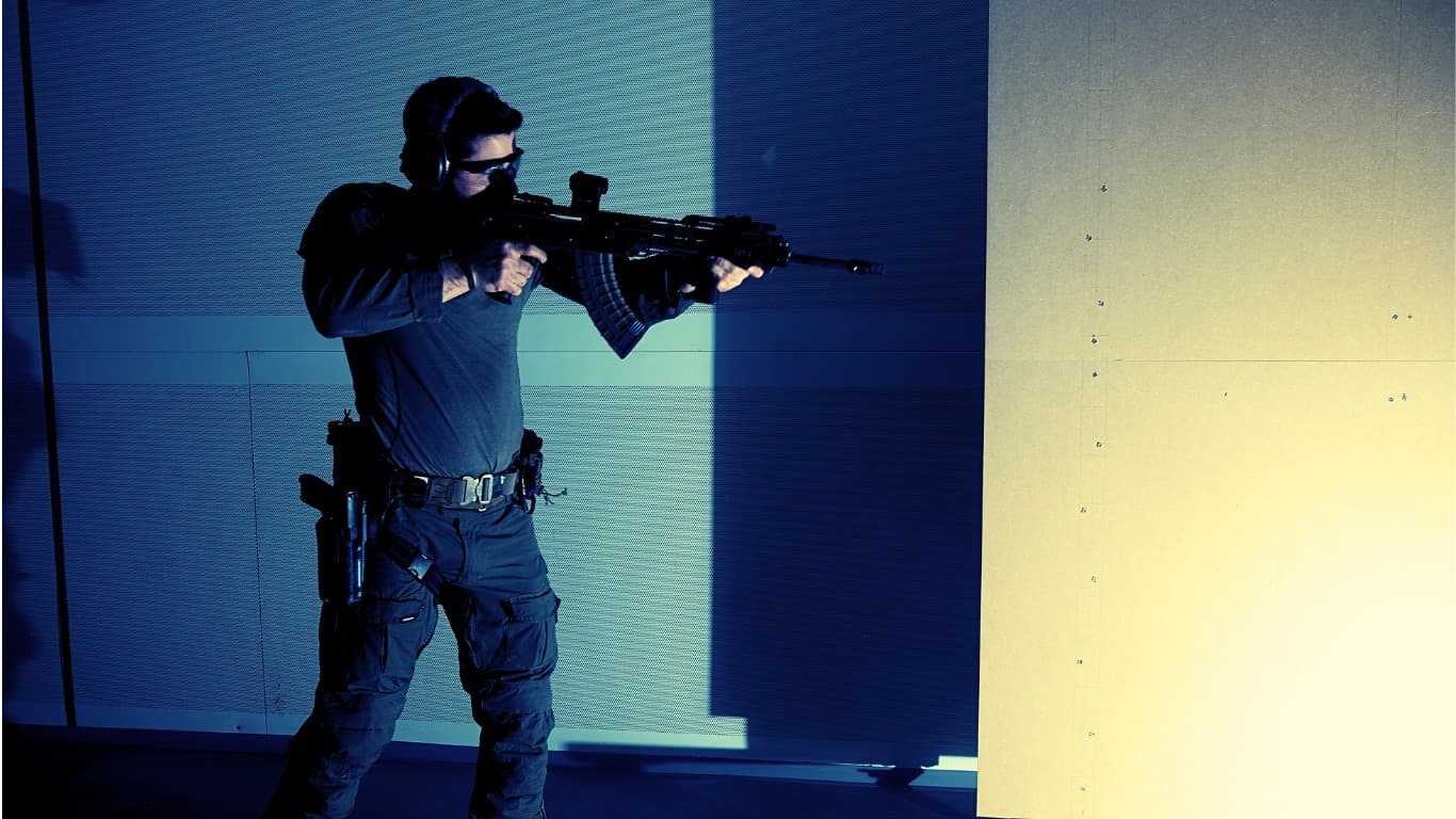 Schütze mit Gewehr in Anschlag im blau beleuchteten Dynamic Room