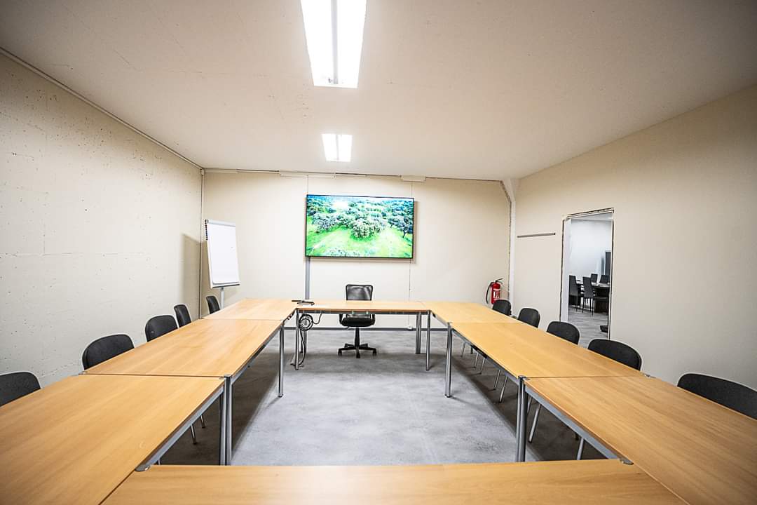 Eventraum mit U-förmiger Tischanordnung und Präsentationsbildschirm