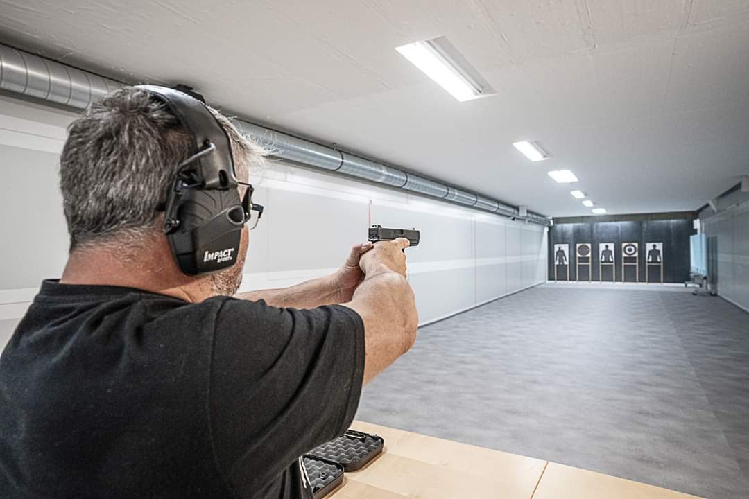Schütze mit Gehörschutz zielt auf der 25-Meter-Bahn von Shooting Point