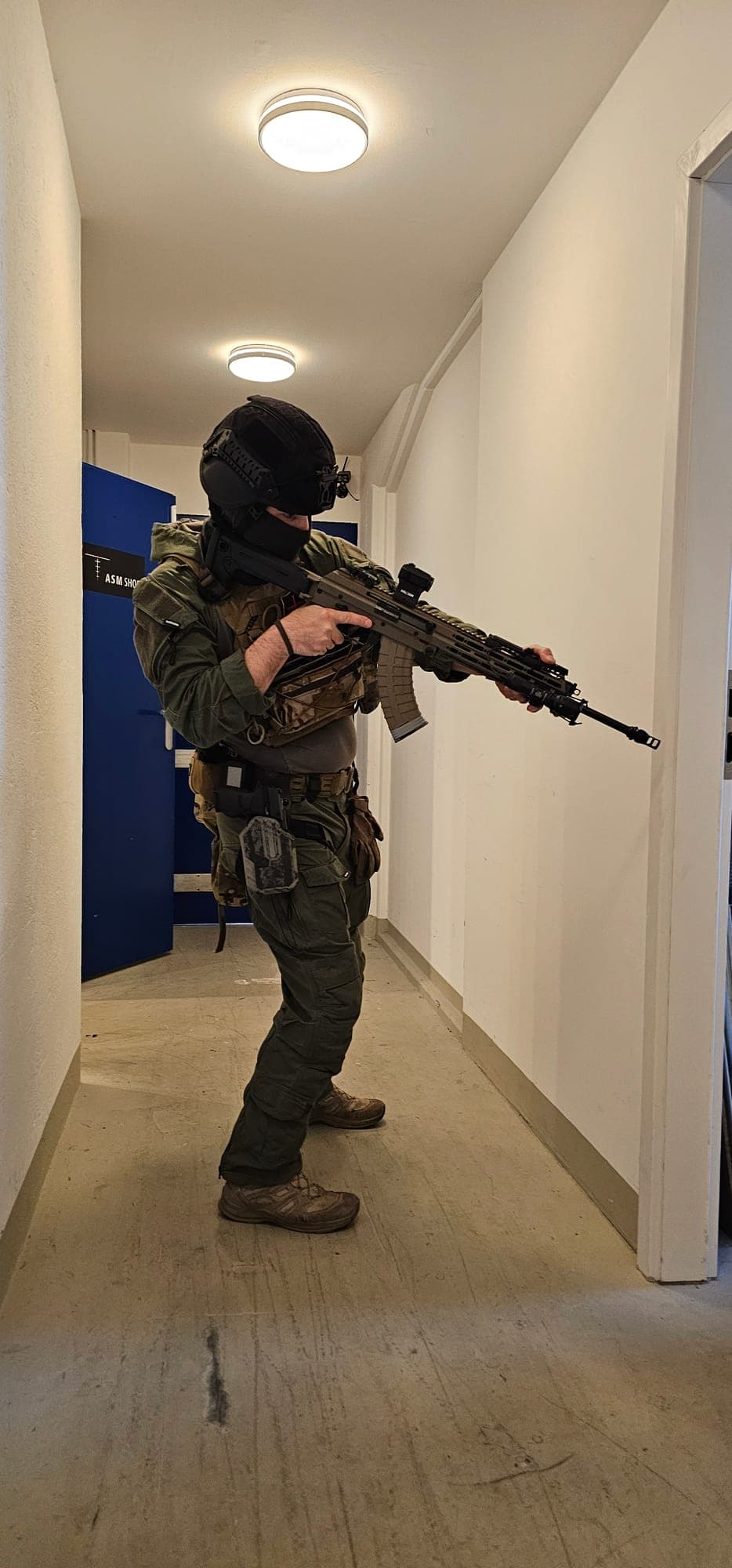 Teilnehmer rückt mit Gewehr durch einen Korridor vor